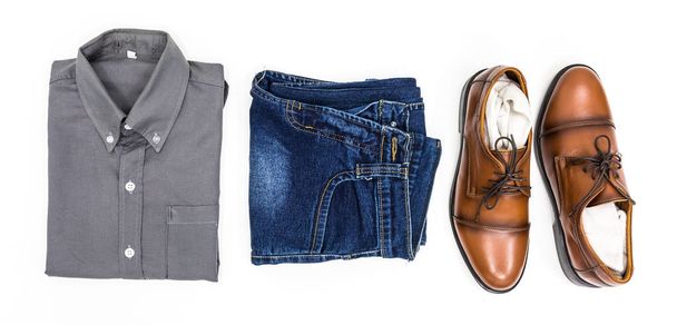 Top ver ropa de los hombres, camisa gris, jean azul, zapatos de cuero de color marrón sobre fondo blanco
. - Foto, imagen
