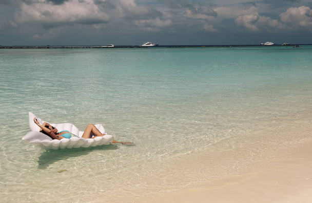 donna in eleganti abiti da spiaggia rilassante sull'isola delle Maldive
 - Foto, immagini