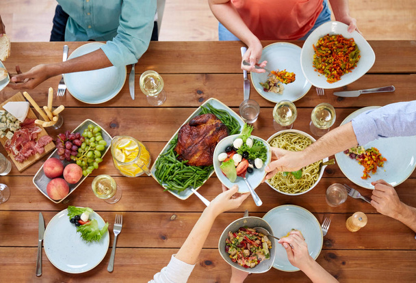 groep mensen eten aan tafel met voedsel - Foto, afbeelding