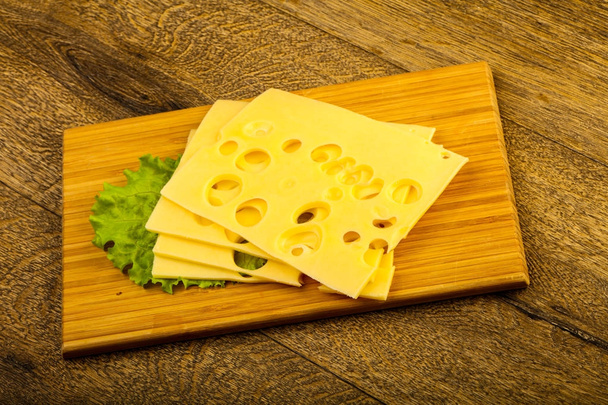 Ahşap arka plan üzerinde dilimlenmiş peynir salata yaprakları - Fotoğraf, Görsel