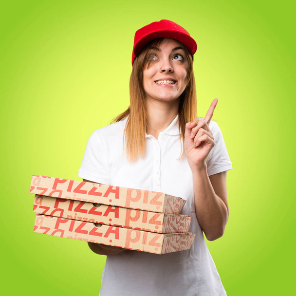 Доставка пиццы женщина указывает на красочный фон
 - Фото, изображение