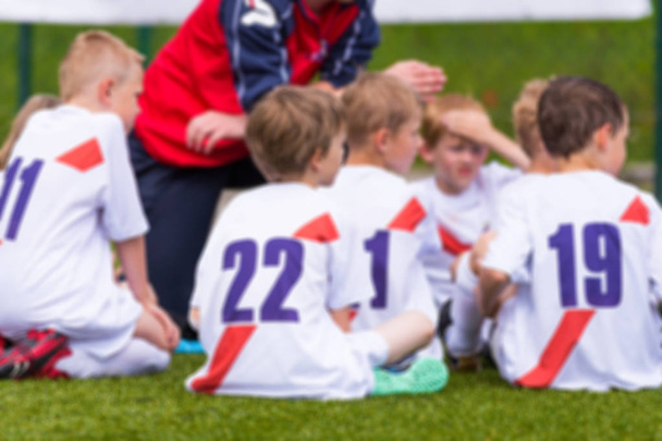 Blurry Antecedentes del equipo de fútbol; Niños con entrenador de fútbol tener charla Pep antes de la competencia de deportes juveniles
 - Foto, imagen