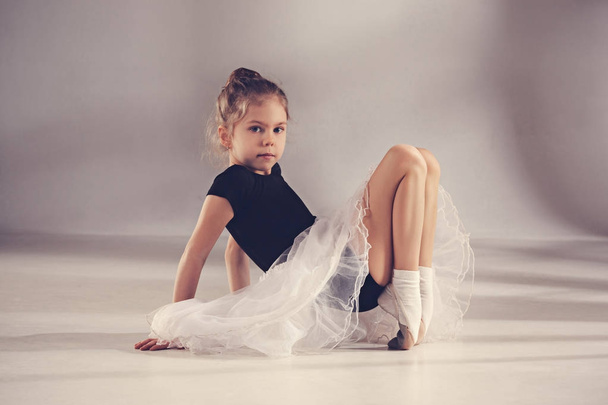 The little balerina dancer on gray background - Foto, afbeelding
