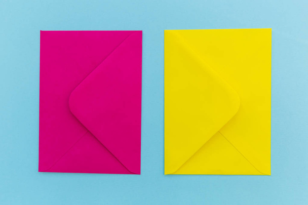 Színes rózsaszín és sárga borítékot a kék háttér - Fotó, kép
