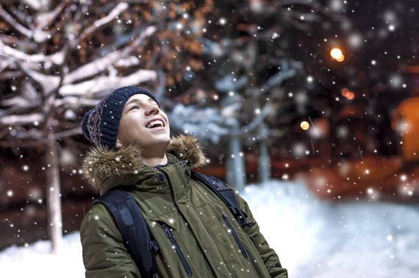 happy young man on a city street during a snowfall - Foto, Imagem