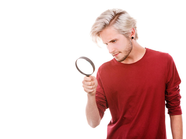 man holds on eye magnifying glass looking through loupe - Φωτογραφία, εικόνα