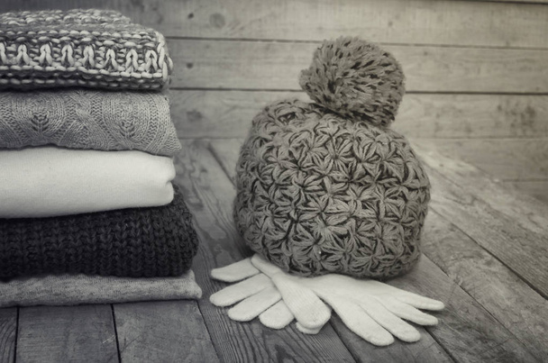 Knitted sweaters and leaves on a wooden background - Фото, зображення