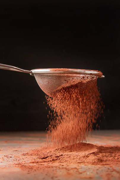 Natural cocoa powder in a sieve for chocolate and baking. Copy s - Фото, изображение