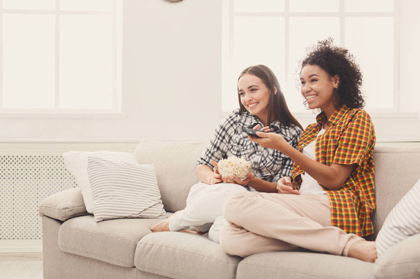 Uśmiechnięte młode kobiety oglądania telewizji w domu - Zdjęcie, obraz