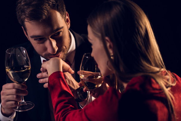 男がレストランでロマンチックなデートに彼女の手にキスしながらワインを飲む女 - 写真・画像