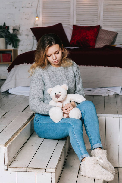 Beautiful smiling woman with long hair holding teddy bear - Foto, imagen