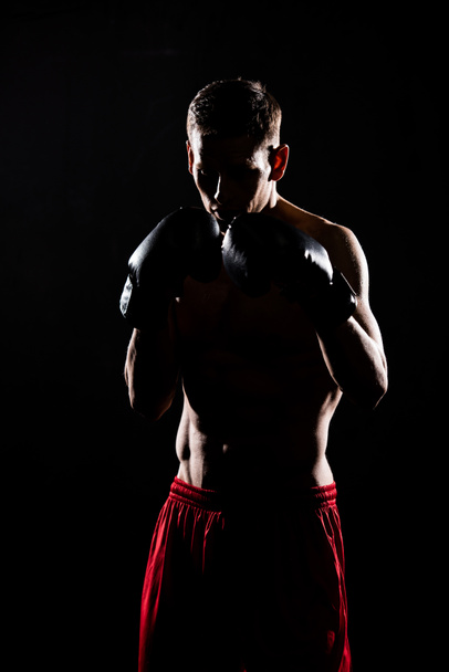 silhouette de jeune sportif en gants de boxe boxe isolé sur noir
 - Photo, image