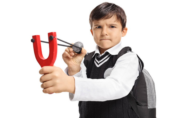 Angry schoolboy aiming with a slingshot and a rock - Photo, Image