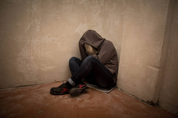 Portret mężczyzny smutna, człowiek uzależniony od narkotyków siedząc na podłodze w rogu - Zdjęcie, obraz
