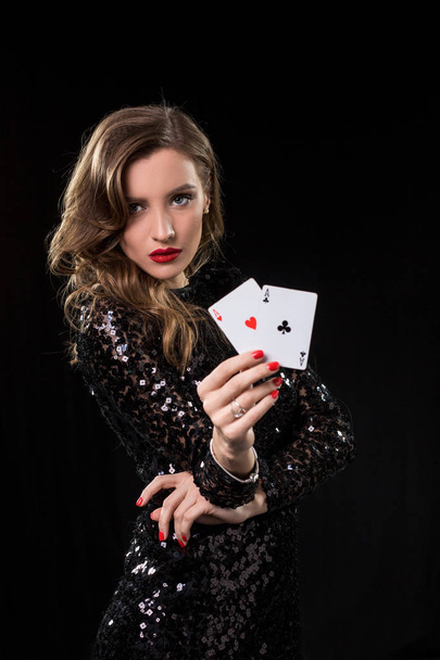 junge Frau mit Spielkarten vor schwarzem Hintergrund - Foto, Bild