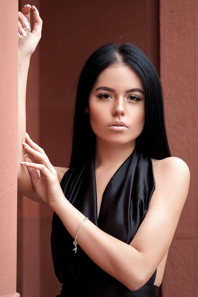 Stijlvolle, luxueuze meisje in een chique zwarte jurk op de straat, fem - Foto, afbeelding