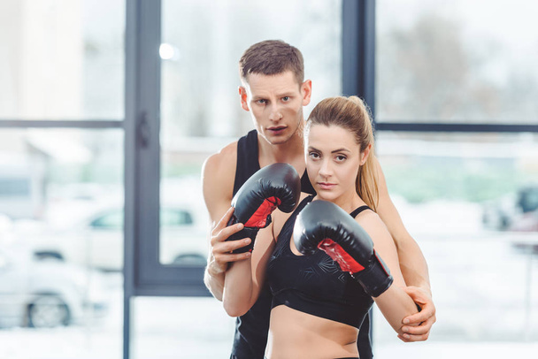 male trainer with beautiful female boxer looking at camera together - Fotografie, Obrázek