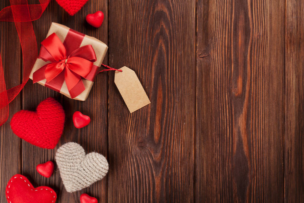 Corazones de San Valentín y cajas de regalo sobre fondo de madera. Vista superior con espacio de copia
 - Foto, imagen