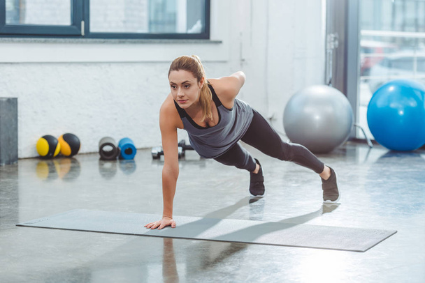 athletic young sportswoman exercising on yoga mat in gym - Φωτογραφία, εικόνα