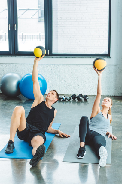 athletic couple exercising with balls together in gym - Foto, Imagem