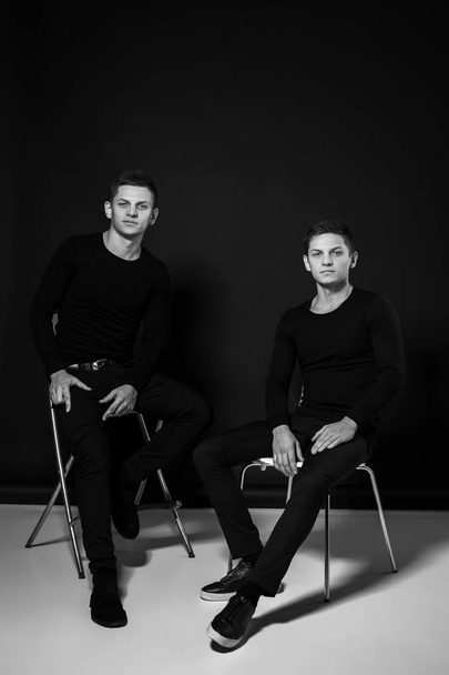 Casual twin brothers. Studio shot. Black and white photography - Фото, изображение