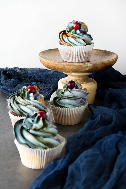 cupcakes on a wooden board. Sweet dessert for a birthday. Dark background - 写真・画像