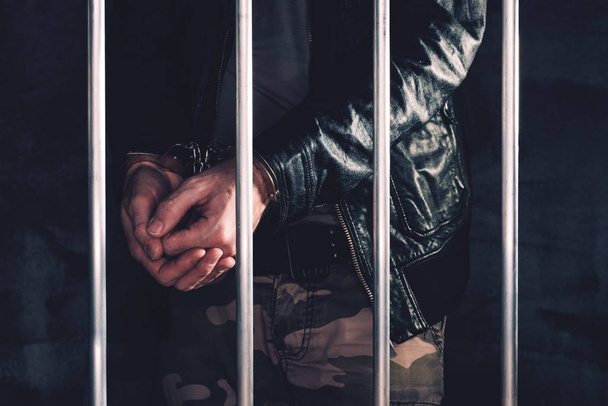 Χειροπέδες ο άνθρωπος πίσω από τα κάγκελα της φυλακής - Φωτογραφία, εικόνα