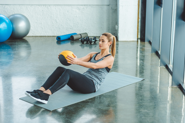 sportswoman doing exercises with ball in gym - Foto, Bild