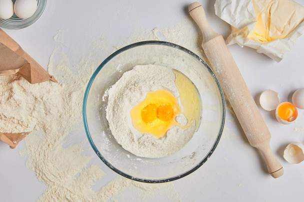 top view of eggs and flour in glass bowl - Foto, Imagem