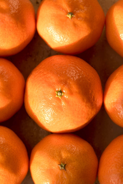 Weergave van bovenaf in detail te beschrijven van een regeling van negen clementines, mandarijnen op de vensterbank, verlicht met warm zonlicht - Foto, afbeelding