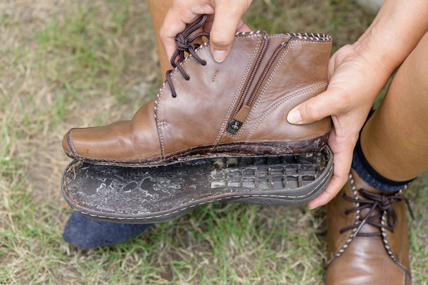 vrouwen schoen heen en weer geslingerd, close-up gebroken vrouwen lederen schoen wilt repareren - Foto, afbeelding