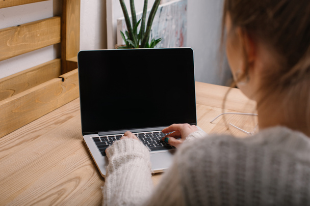 обрезанное изображение девушки, работающей с ноутбуком в офисе
 - Фото, изображение