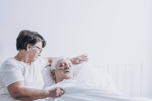 Elderly lady comforting her husband - Photo, image