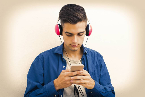 jeune adolescent moderne avec téléphone et écouteurs écoutant de la musique
 - Photo, image