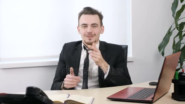 Young businessman in suit sitting in office and covers his mouth with his hands, silence sign. 60 fps - Imágenes, Vídeo