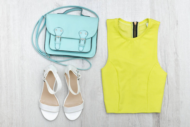 Μπλούζα πράσινο lime, λευκά αθλητικά παπούτσια και τσάντα. Μοντέρνα έννοια - Φωτογραφία, εικόνα