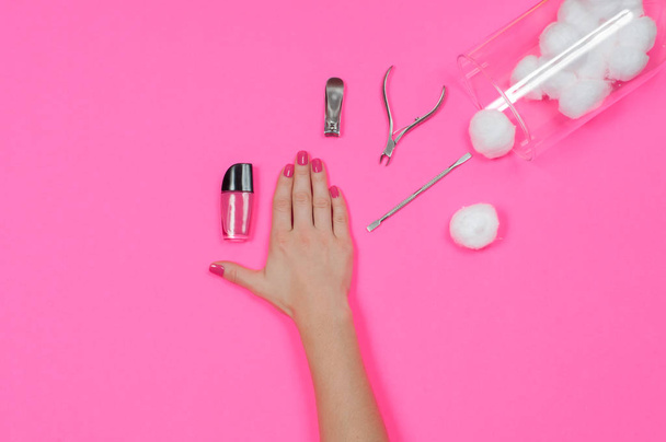 Nail salon. Beautiful female hand with pink nail polish - Foto, afbeelding