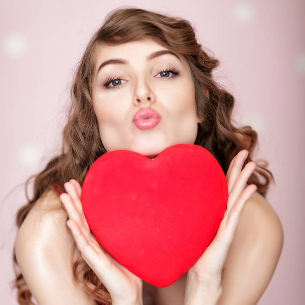 woman with red hearts on pink background. - Foto, Imagem