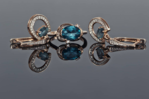 Χρυσά σκουλαρίκια και δαχτυλίδι με μπλε τοπάζι - Φωτογραφία, εικόνα