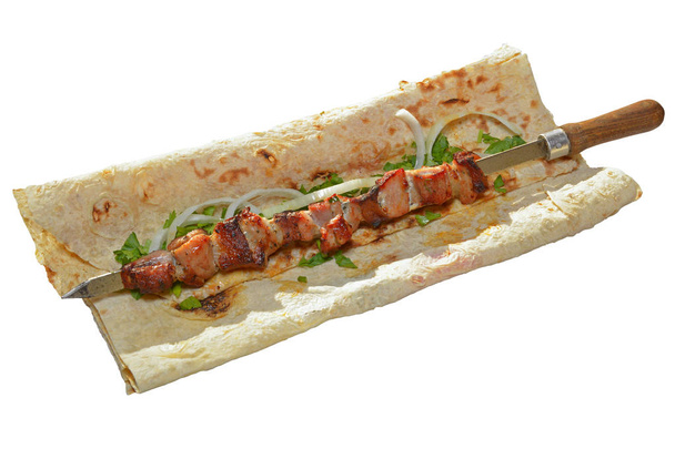 barbacoa de cerdo en brocheta servida con cebolla en rodajas y perejil sobre lavash armenio (pan pita) aislado sobre fondo blanco
 - Foto, Imagen