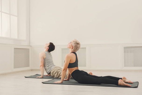 Man and woman training yoga in cobra pose. - Photo, image