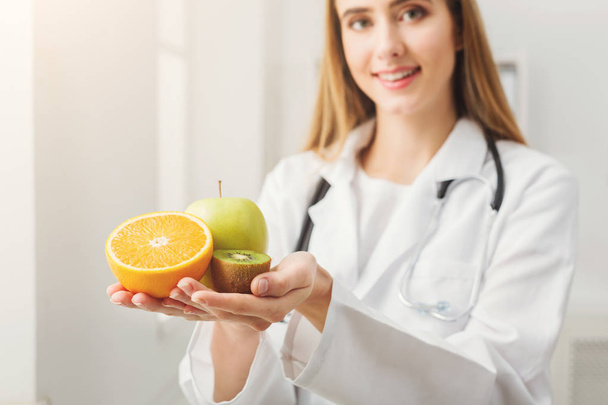 Lachende voedingsdeskundige vrouw met fruit op kantoor - Foto, afbeelding