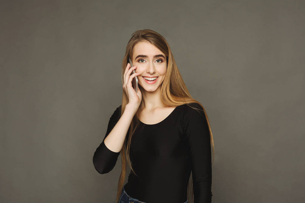 Hymyilevä kaunis nainen puhuu puhelimessa
 - Valokuva, kuva