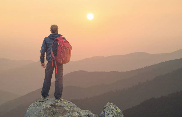 Turista no pico de rochas altas durante o pôr do sol. Esporte e vida ativa concep
 - Foto, Imagem
