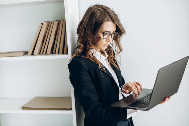 Чарівна бізнес-леді з ноутбуком в руках в її офісі
 - Фото, зображення