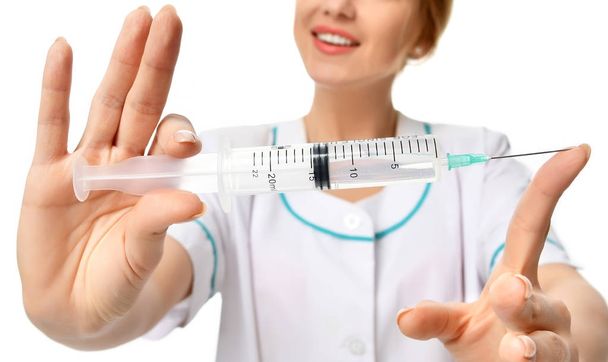 Doctor or nurse with big syringe needle for flu injection vaccination concept  - 写真・画像