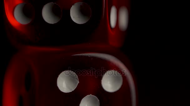 Two red casino dices on the black background. Shot glasses with dice and ribbon. risk concept - playing dice at black wooden background. Playing a game with dice. Red casino dice rolls. - Footage, Video