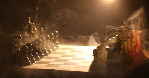 Chess board game concept of business ideas and competition and strategy ideas concept. Chess figures on a dark background with smoke and fog. Selective focus - Footage, Video