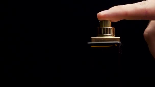 Flakon perfum na czarnym tle. zbliżenie z spray butelki krople na czarnym tle - Materiał filmowy, wideo