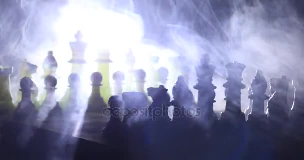 Chess board game concept of business ideas and competition and strategy ideas concept. Chess figures on a dark background with smoke and fog. Selective focus - Footage, Video